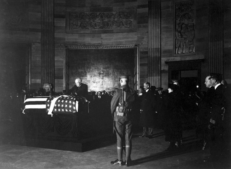 Warren Harding placing a wreath on the casket of the Unknown Soldier, while other government and military officials stand around